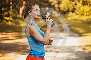 Woman athlete takes a break, she drinking