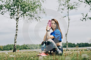 woman athlete takes a break  she drinking water  out on a run on a hot day