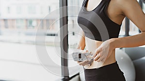 Woman athlete using body fat measurement and waist size with digital caliper