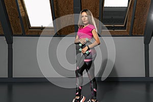 Woman of athletic physique is workout with dumbbells. Athletic girl during training. Fitness trainer