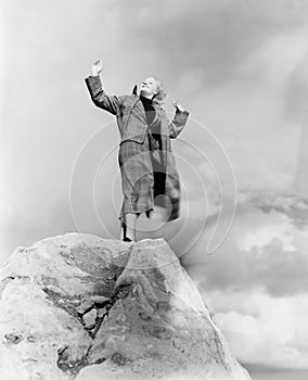 Woman atop rock on windy day