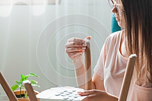 Woman attach felt pad on chair leg, care of floor