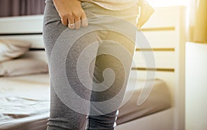 Woman attempt putting or wearing her pants in dressing room