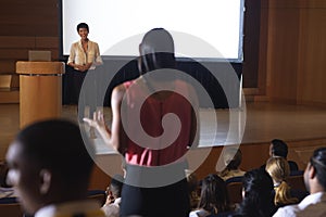 Woman from the audience standing and asking query in the auditorium