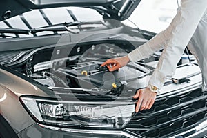 Woman is in autosalon at daytime