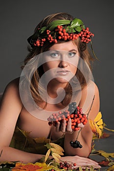 woman in autumn leaves and a wreath of mountain ash