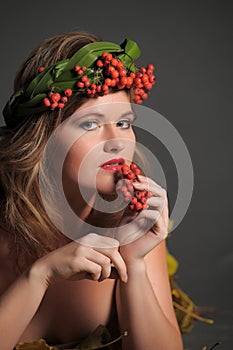 woman in autumn leaves and a wreath of mountain ash