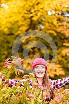 Woman in autumn park throwing leaves up in the air