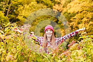 Woman in autumn park throwing leaves up in the air