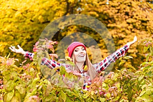 Woman in autumn park throwing leaves up in the air