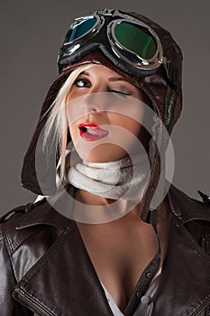 Woman in aviator helmet winks and licking lips