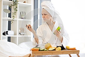 Woman with avocado scanning skincare product in bedroom