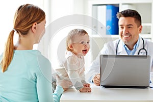 Woman with baby and doctor with laptop at clinic