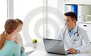 Woman with baby and doctor with laptop at clinic