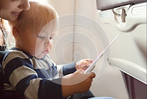 Woman and baby girl reading announcement in plane