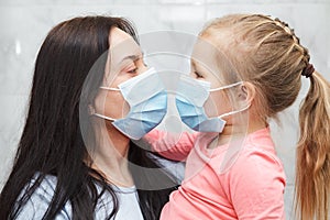 Quarantined woman and baby girl wearing medical masks photo