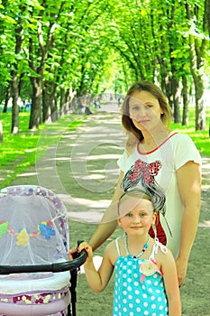 Woman with baby in perambulator and elder daughter