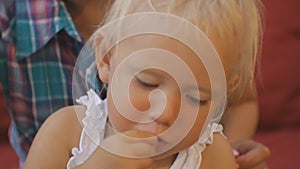 Woman with baby trying japanese cuisine. Close-up of blonde blue-eyed baby girl taking by hand and biting cabbage on