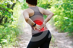 Woman with back pain, kidney inflammation, injury during workout