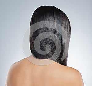 Woman, back and straight hair care from beauty or cosmetics on studio background. Model, head and girl with healthy