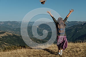 Woman back traveler tosses a hat against the background of the m photo