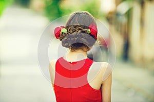 Woman back view with red roses in stylish hair
