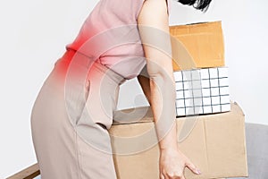 woman with a backache while lifting boxes, back pain caused by wrong movement