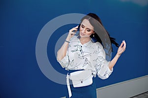 Woman on a background of blue color wall.