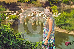 Woman on a background of flamingos on a pond photo