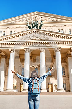 Woman with a backpack admiring the majestic architecture and view of the Bolshoi Theater, tourism in Moscow and
