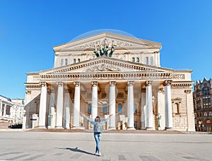 Woman with a backpack admiring the majestic architecture and view of the Bolshoi Theater, tourism in Moscow and
