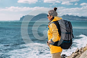 A woman with a backpack on the background of the sea. Portrait of a woman in tourist gear on the background of the sea.