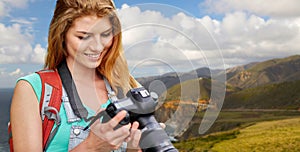 Woman with backpack and camera at big sur coast