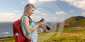 Woman with backpack and camera at big sur coast