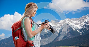 Woman with backpack and camera over alps mountains