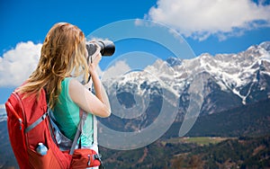 Woman with backpack and camera over alps mountains