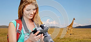 Woman with backpack and camera over savannah