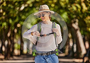 Woman, backpack and checking watch in nature travel, sightseeing or adventure in park, trees forest or Canada woods