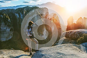 Woman with backpack enjoying sunrise on mountain