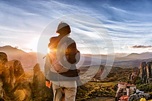 Woman with backpack enjoying sunrise on mountain