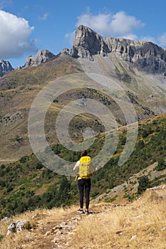 Woman with backpack hiking in the Hecho Valley, Western Valleys Natural Park, Huesca. photo
