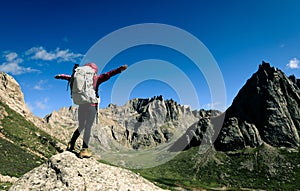 woman with backpack hiking on high altitude mountain top