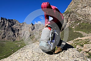 Woman with backpack hiking in mountains