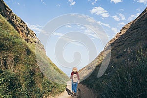 Woman with backpack hiking in the mountains