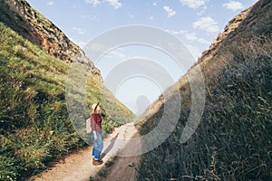 Woman with backpack hiking in the mountains