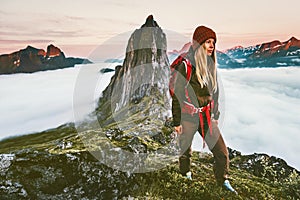 Woman with backpack hiking in sunset mountains adventure
