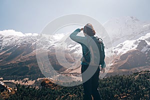 Woman with backpack looking on beautiful mountains