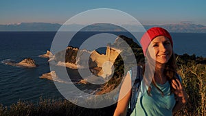 Woman with a backpack and map goes to the Cape Drastis at Corfu island in Greece