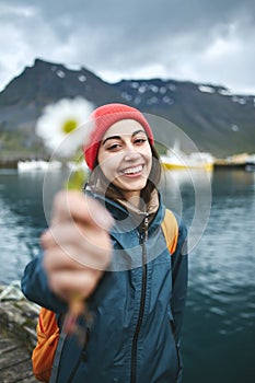 Woman with backpack on pier with flower