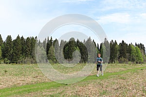 Woman with a backpack running on forest trail